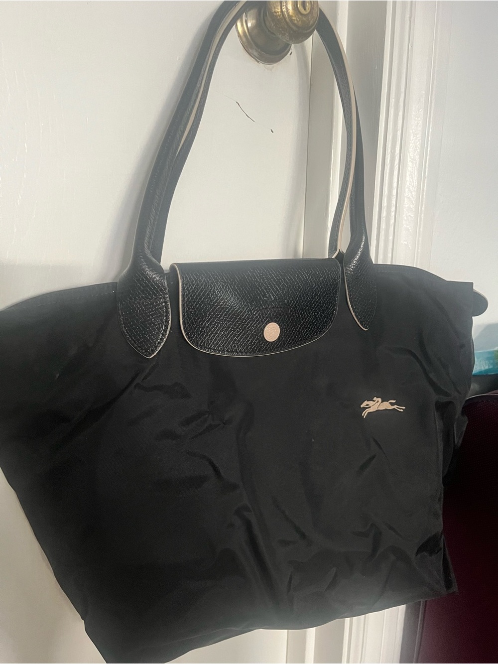 Black Longchamp Le Pliage bag large with front logo and black/cream handles.